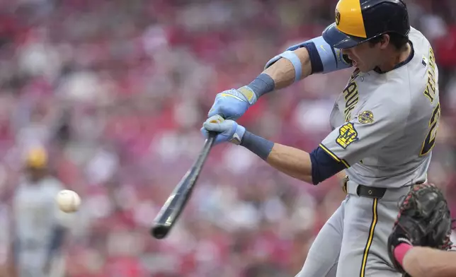Milwaukee Brewers' Christian Yelich hits a one-run single in the first inning of a baseball game against the Cincinnati Reds, Tuesday, June 3, 2025, in Cincinnati. (AP Photo/Kareem Elgazzar)
