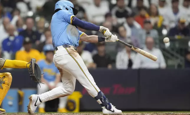 Milwaukee Brewers' Isaac Collins hits an RBI single during the eighth inning of a baseball game against the San Diego Padres, Saturday, June 7, 2025, in Milwaukee. (AP Photo/Aaron Gash)