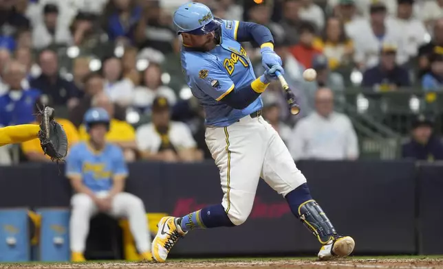 Milwaukee Brewers' Rhys Hoskins hits an RBI sacrifice fly during the eighth inning of a baseball game against the San Diego Padres, Saturday, June 7, 2025, in Milwaukee. (AP Photo/Aaron Gash)