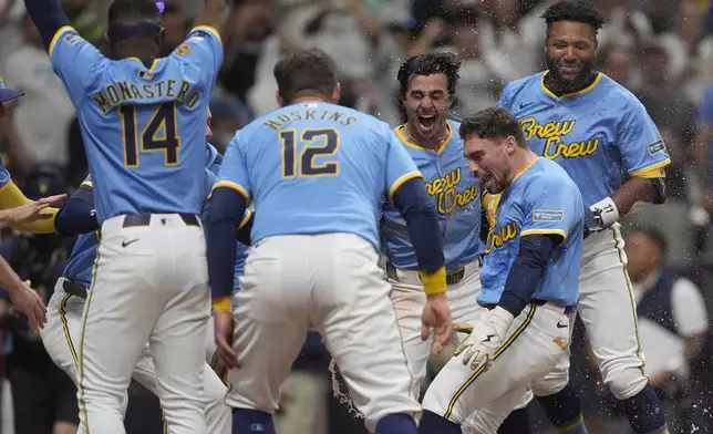 Milwaukee Brewers' Caleb Durbin is congratulated by teammates after hitting a walk off solo home run during the ninth inning of a baseball game against the San Diego Padres, Saturday, June 7, 2025, in Milwaukee. (AP Photo/Aaron Gash)