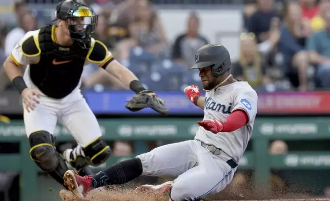 Miami Marlins' Otto Lopez, right, scores as Pittsburgh Pirates catcher Henry Davis, left, waits for the late throw during the fourth inning of a baseball game Tuesday, June 10, 2025, in Pittsburgh. (AP Photo/Matt Freed)