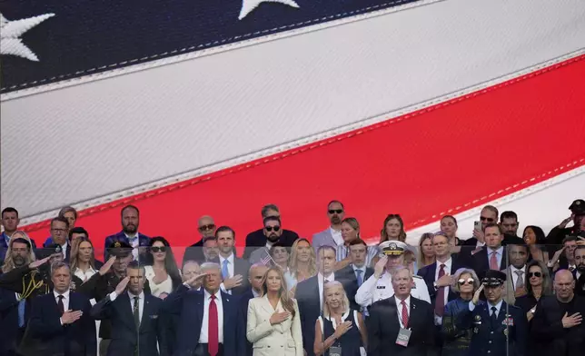 President Donald Trump, first lady Melania Trump, and other guests stand for the National Anthem, during a military parade commemorating the Army's 250th anniversary, coinciding with his 79th birthday, Saturday, June 14, 2025, in Washington. (AP Photo/Julia Demaree Nikhinson)