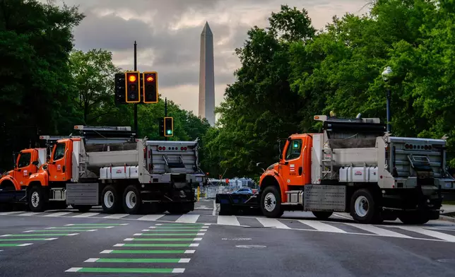 The Washington Monument is seen as dump trucks block an intersection ahead of an upcoming military parade commemorating the U.S. Army's 250th anniversary and coinciding with President Donald Trump's 79th birthday, Saturday, June 14, 2025, in Washington (AP Photo/Julia Demaree Nikhinson)