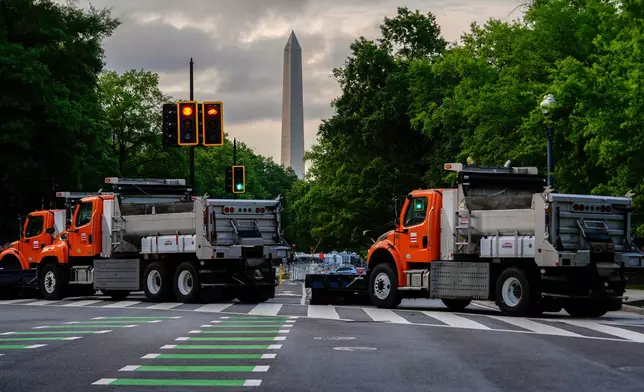 The Washington Monument is seen as dump trucks block an intersection ahead of an upcoming military parade commemorating the U.S. Army's 250th anniversary and coinciding with President Donald Trump's 79th birthday, Saturday, June 14, 2025, in Washington (AP Photo/Julia Demaree Nikhinson)