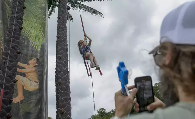 Vivian Davis, 7, of Hartsville, Tenn., makes her way down from the Coconut Tree Climb during the festival event to honor the Army's 250th anniversary, coinciding with President Donald Trump's 79th birthday, Saturday, June 14, 2025, on the National Mall in Washington. (AP Photo/Rod Lamkey, Jr.)