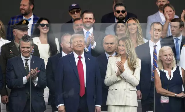 President Donald Trump, first lady Melania Trump, and Defense Secretary Pete Hegseth, left, attend a military parade commemorating the Army's 250th anniversary, coinciding with his 79th birthday, Saturday, June 14, 2025, in Washington. (AP Photo/Julia Demaree Nikhinson)