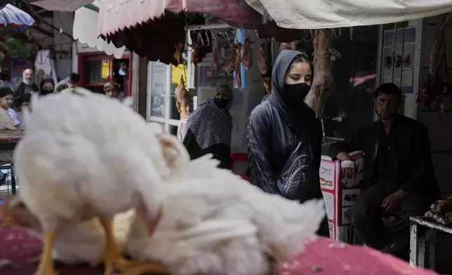 A woman walks in a market in Kabul, Afghanistan, Thursday, June 5, 2025. (AP Photo/Ebrahim Noroozi)