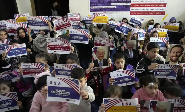 FILE - Afghan refugees hold placards during their meeting to discuss situation after President Donald Trump paused the U.S. refugee programs, in Islamabad, Pakistan, Friday, Jan. 24, 2025. (AP Photo/Anjum Naveed, File)