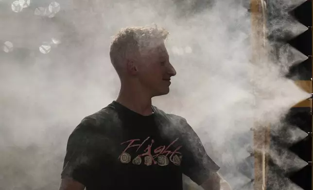 Nolan Kelehel cools off in a mister at Kauffman Stadium before a baseball game between the Kansas City Royals and the Tampa Bay Rays, Wednesday, June 25, 2025, in Kansas City, Mo. (AP Photo/Charlie Riedel)