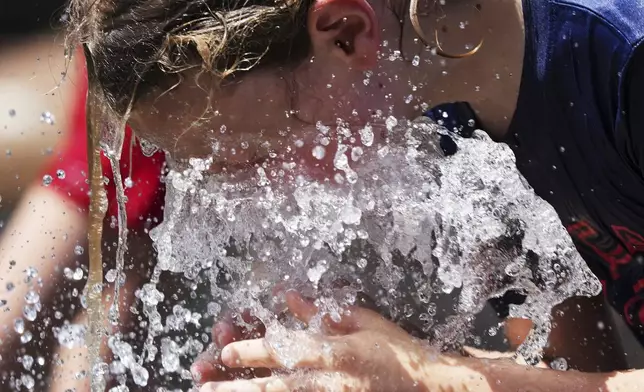 Jude Puroway cools off at a fountain during hot weather in Chicago, Sunday, June 22, 2025. (AP Photo/Nam Y. Huh)
