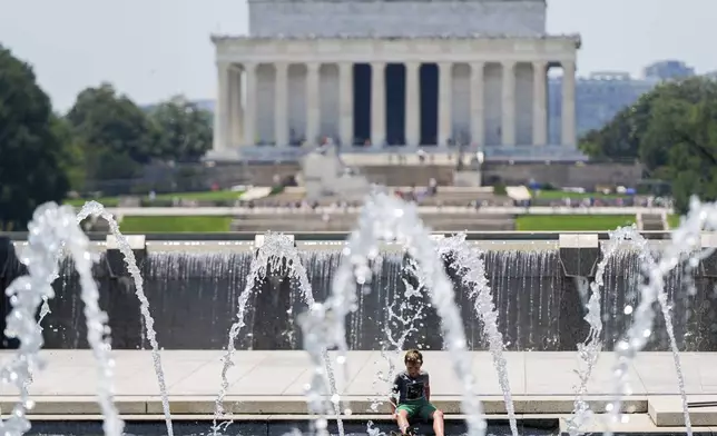 A boy cools off at the World War II Memorial, Tuesday, June 24, 2025, in Washington. (AP Photo/Julia Demaree Nikhinson)