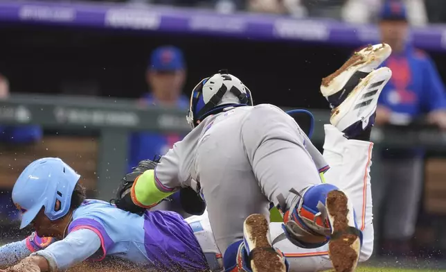 New York Mets catcher Francisco Alvarez, front, tags out Colorado Rockies' Ryan Ritter as he tries to score on a ground ball hit by Mickey Moniak in the fifth inning of a baseball game Friday, June 6, 2025, in Denver. (AP Photo/David Zalubowski)