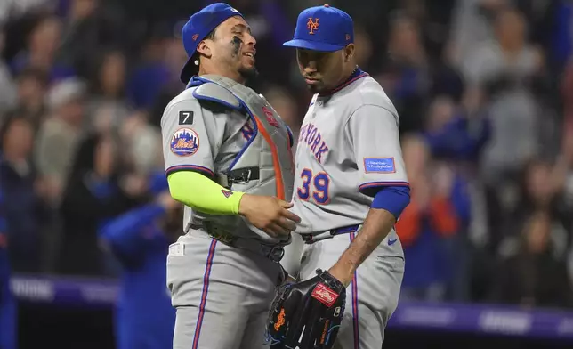 New York Mets catcher Francisco Alvarez, left, congratulates relief pitcher Edwin Díaz after a baseball game against the Colorado Rockies Friday, June 6, 2025, in Denver. (AP Photo/David Zalubowski)