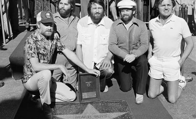Members of The Beach Boys, from left, Mike Love, Carl Wilson, Brian Wilson, Al Jardine and Bruce Johnston, pose with their star on the Hollywood Walk of Fame, during a ceremony in Los Angeles on Dec. 30, 1980. (AP Photo/Lennox McLendon, File)