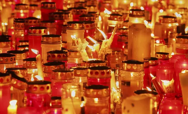 Candles light on the main square in the city center after a deadly shooting at a school in Graz, Austria, Tuesday, June 10, 2025. (AP Photo/Heinz-Peter Bader)