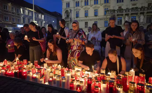 People light candles for victims of a former student who opened fire at a school, fatally wounding 10 people and injuring many others before taking his own life, in Graz, Austria, Tuesday, June 10, 2025. (AP Photo/Darko Bandic)