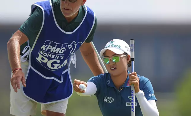 Minjee Lee, right, and her caddie Michael Paterson strategize for a putt on the first green during the final round of the Women's PGA Championship golf tournament Sunday, June 22, 2025, in Frisco, Texas. (AP Photo/LM Otero)