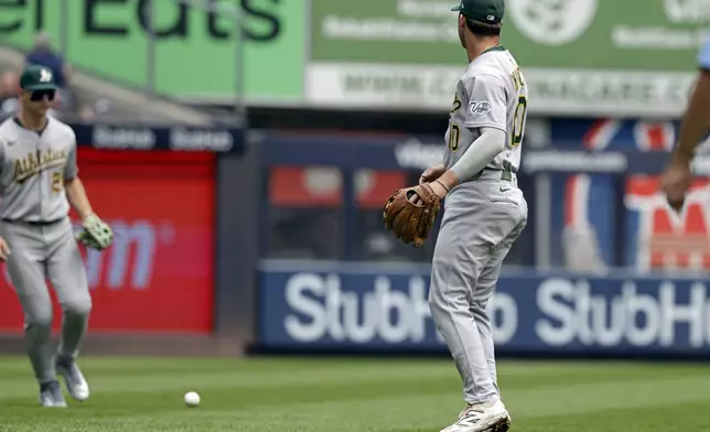 Athletics third base Max Muncy (10) watches as a fly ball hit by New York Yankees' Cody Bellinger falls in front of Athletics outfielder Tyler Soderstrom during the first inning of a baseball, game Sunday, June 29, 2025, in New York. (AP Photo/Adam Hunger)