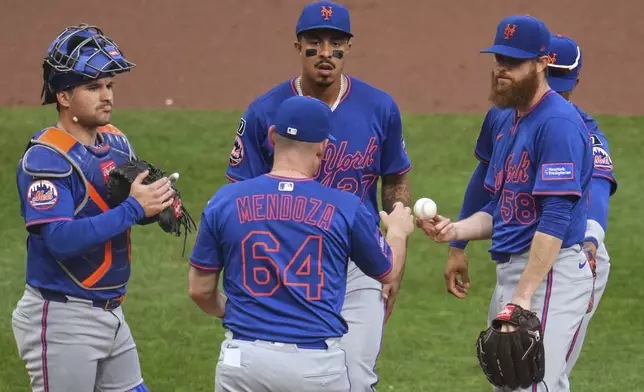 New York Mets pitcher Paul Blackburn (58) hands the ball to manager Carlos Mendoza (64) as he is removed from a baseball game during the second inning against the Pittsburgh Pirates in Pittsburgh, Saturday, June 28, 2025. (AP Photo/Gene J. Puskar)