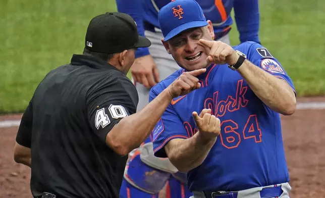 New York Mets manager Carlos Mendoza (64) makes his point to home plate umpire Roberto Ortiz (40) during the fourth inning of a baseball game against the Pittsburgh Pirates in Pittsburgh, Saturday, June 28, 2025. (AP Photo/Gene J. Puskar)
