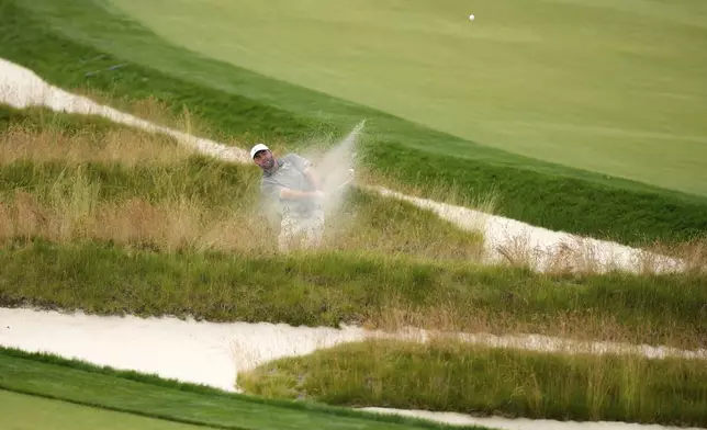 Scottie Scheffler plays out of the Church Pews bunker on the third hole during the second round of the U.S. Open golf tournament at Oakmont Country Club Friday, June 13, 2025, in Oakmont, Pa. (AP Photo/Charlie Riedel)