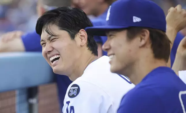 Los Angeles Dodgers' Shohei Ohtani reacts alongside Yoshinobu Yamamoto during the eighth inning of a baseball game against the San Francisco Giants in Los Angeles, Sunday, June 15, 2025. (AP Photo/Jessie Alcheh)