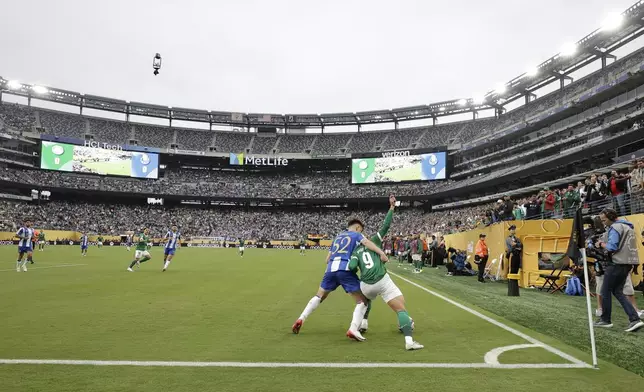 Palmeiras' Vitor Roque, right, is challenged by Porto's Martim Fernandes during the Club World Cup group A soccer match between Palmeiras and FC Porto in East Rutherford, NJ, Sunday, June 15, 2025. (AP Photo/Adam Hunger)