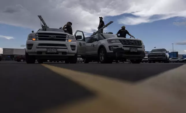 Members of the University of Colorado Boulder's Integrated Remote and In-Situ Sensing flight team stage in a Walmart parking lot before a Project ICECHIP operation Tuesday, June 3, 2025, in Atlus, Okla. (AP Photo/Carolyn Kaster)