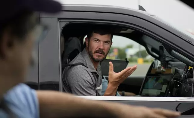 Victor Gensini, Northern Illinois University meteorology professor and a lead scientist of Project ICECHIP, speaks with Seth Borenstein, Associated Press science writer, as they stage in a Walmart parking lot before a Project ICECHIP operation Tuesday, June 3, 2025, in Atlus, Okla. (AP Photo/Carolyn Kaster)