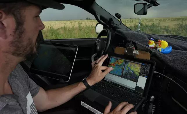 Victor Gensini, Northern Illinois University meteorology professor and a lead scientist of Project ICECHIP, checks storm data in the command vehicle during an operation Tuesday, June 3, 2025, south of Tipton, Okla.(AP Photo/Carolyn Kaster)
