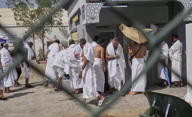 Pilgrims wash for prayers near the rocky hill known as the Mountain of Mercy, on the Plain of Arafat, during the annual Hajj pilgrimage near the holy city of Mecca, Saudi Arabia, Thursday, June 5, 2025. (AP Photo/Amr Nabil)
