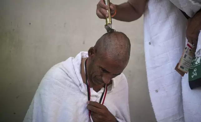 A Muslim pilgrim shaves his head, a significant part of the Umrah and Hajj rituals in Islam, during the symbolic stoning of the devil, the last rite of the annual Hajj, in Mina near the holy city of Mecca, Saudi Arabia, Friday, June 6, 2025. (AP Photo/Amr Nabil)