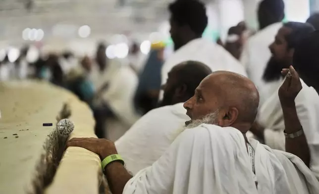 A Muslim pilgrim casts stones at a pillar in the symbolic stoning of the devil, the last rite of the annual Hajj, in Mina near the holy city of Mecca, Saudi Arabia, Friday, June 6, 2025. (AP Photo/Amr Nabil)