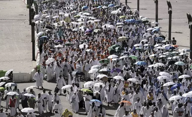 Muslim pilgrims walk on their way to cast stones at pillars in the symbolic stoning of the devil, the last rite of the annual Hajj, in Mina near the holy city of Mecca, Saudi Arabia, Friday, June 6, 2025. (AP Photo/Amr Nabil)