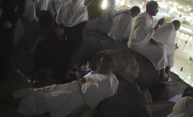 Muslim pilgrims pray on the rocky hill known as the Mountain of Mercy on the Plain of Arafat during the annual Hajj pilgrimage near the holy city of Mecca, Saudi Arabia, Thursday, June 5, 2025. (AP Photo/Amr Nabil)