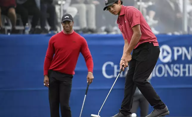 FILE - Tiger Woods watches his son, Charlie Woods, putt on the 18th green during the final round of the PNC Championship golf tournament, in Orlando, Fla., Dec. 22, 2024. (AP Photo/Phelan M. Ebenhack, File)