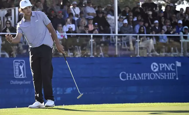 FILE - Charlie Woods reacts to his putt on the 18th green during the first round of the PNC Championship golf tournament, Dec. 21, 2024, in Orlando, Fla. (AP Photo/Phelan M. Ebenhack, File)