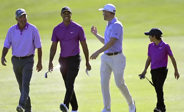 FILE - Tiger Woods, second from left, and his son Charlie, right, walk with Justin Thomas, second from right, and his father Mike Thomas on the third fairway during the first round of the PNC Championship golf tournament in Orlando, Fla., Dec. 19, 2020. (AP Photo/Phelan M. Ebenhack, File)
