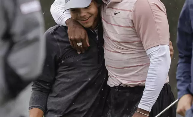 FILE - Tiger Woods hugs his son Charlie, at the end of the first round of the PNC Championship golf tournament, in Orlando, Fla., Dec. 16, 2023. (AP Photo/Kevin Kolczynski, File)
