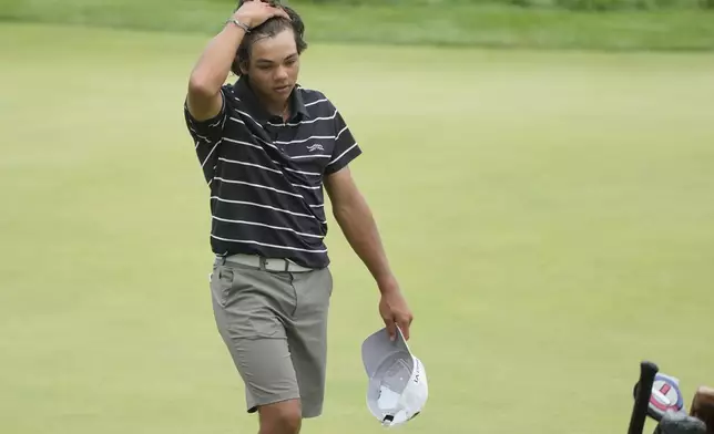 FILE - Charlie Woods walks off the 18th green during the first round of stroke play of the U.S. Junior Amateur Golf Championship, in Bloomfield Township, Mich., July 22, 2024. (AP Photo/Carlos Osorio, File)
