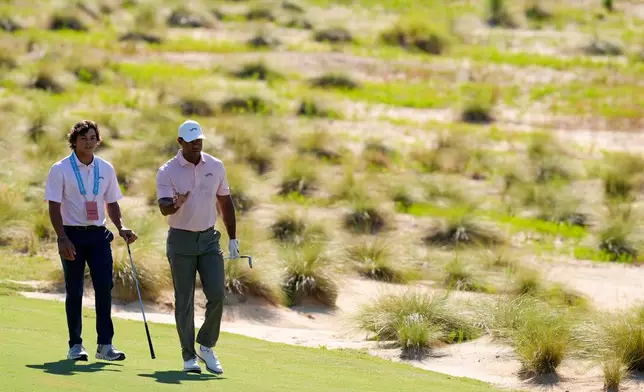 FILE - Tiger Woods walks with his son Charlie, on the sixth hole during a practice round for the U.S. Open golf tournament in Pinehurst, N.C., June 11, 2024. (AP Photo/George Walker IV, File)