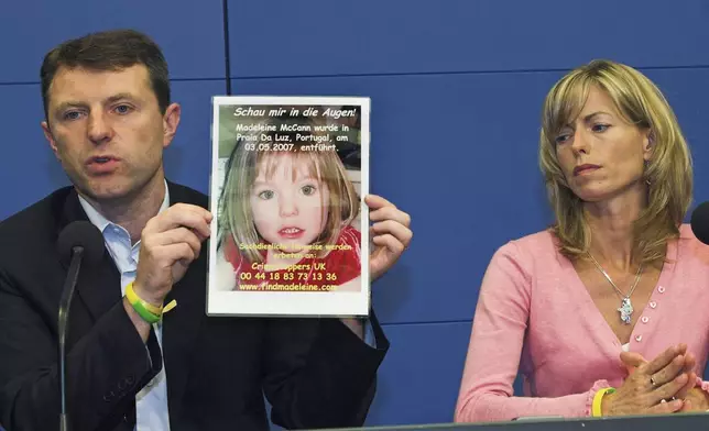 FILE - Gerry, left, and Kate McCann, parents of four-year old Madeleine McCann, present a picture of their daughter during a press conference in Berlin, Wednesday, June 6, 2007. (AP Photo/Sven Kaestner, File)