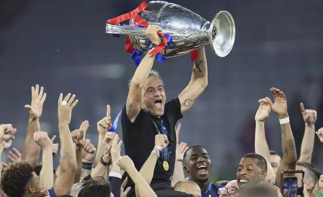 PSG's head coach Luis Enrique lifts the trophy after the Champions League final soccer match between Paris Saint-Germain and Inter Milan at the Allianz Arena in Munich, Germany, Saturday, May 31, 2025. (AP Photo/Alexandra Beier)