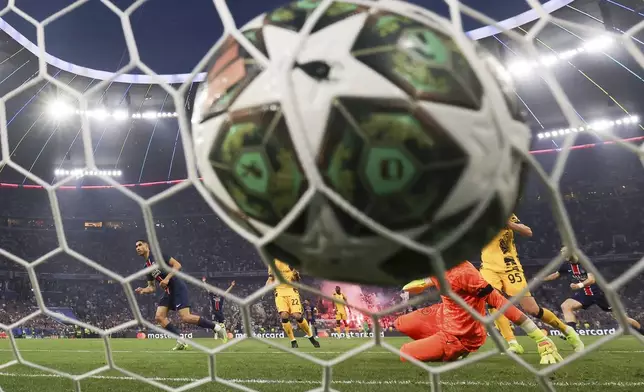 PSG's Achraf Hakimi, left, scores his side's opening goal during the Champions League final soccer match between Paris Saint Germain and Inter Milan, at the Allianz Arena in Munich, Germany, Saturday, May 31, 2025. (Christian Charisius/dpa via AP)