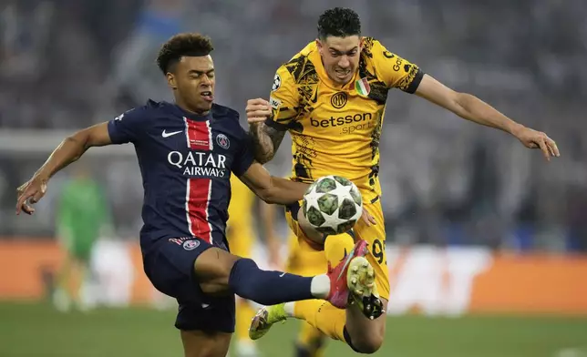 PSG's Desire Doue, left, challenges for the ball with Inter Milan's Alessandro Bastoni during the Champions League final soccer match between Paris Saint-Germain and Inter Milan at the Allianz Arena in Munich, Germany, Saturday, May 31, 2025. (AP Photo/Matthias Schrader)