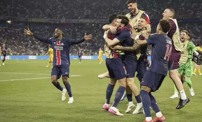 PSG's Khvicha Kvaratskhelia, center, celebrates with his teammates after scoring his side's fourth goal during the Champions League final soccer match between Paris Saint-Germain and Inter Milan at the Allianz Arena in Munich, Germany, Saturday, May 31, 2025. (AP Photo/Martin Meissner)
