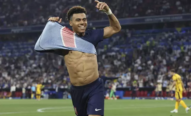 PSG's Desire Doue celebrates after he scored his side's third goal during the Champions League final soccer match between Paris Saint-Germain and Inter Milan at the Allianz Arena in Munich, Germany, Saturday, May 31, 2025. (AP Photo/Alexandra Beier)