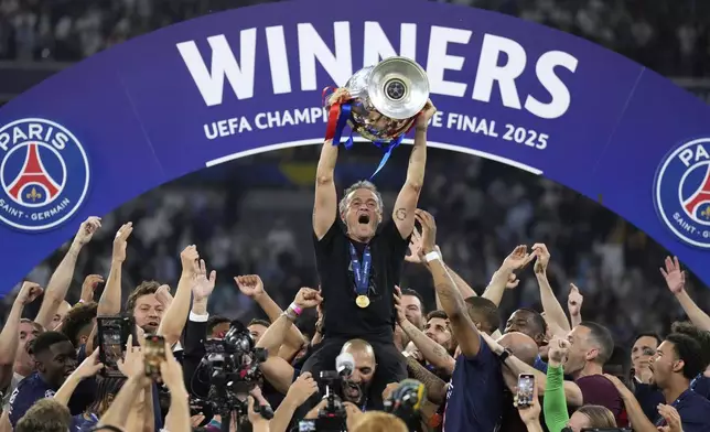 PSG's head coach Luis Enrique celebrates with the trophy after winning the Champions League final soccer match between Paris Saint-Germain and Inter Milan at the Allianz Arena in Munich, Germany, Saturday, May 31, 2025. (AP Photo/Matthias Schrader)