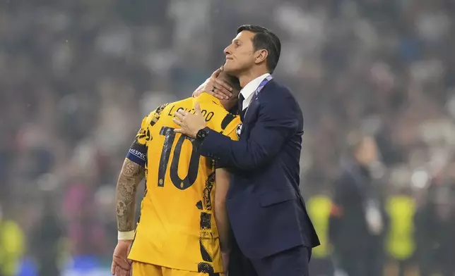 Former Inter Milan player Javier Zanetti, right, hugs Inter Milan's team captain Lautaro Martinez at the end of the Champions League final soccer match between Paris Saint-Germain and Inter Milan at the Allianz Arena in Munich, Germany, Saturday, May 31, 2025. (AP Photo/Luca Bruno)