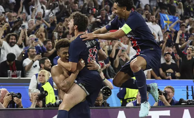 PSG's Desire Doue, left, celebrates after he scored his side's third goal during the Champions League final soccer match between Paris Saint-Germain and Inter Milan at the Allianz Arena in Munich, Germany, Saturday, May 31, 2025. (AP Photo/Alexandra Beier)